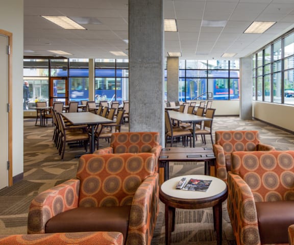 A large room with orange chairs and tables.