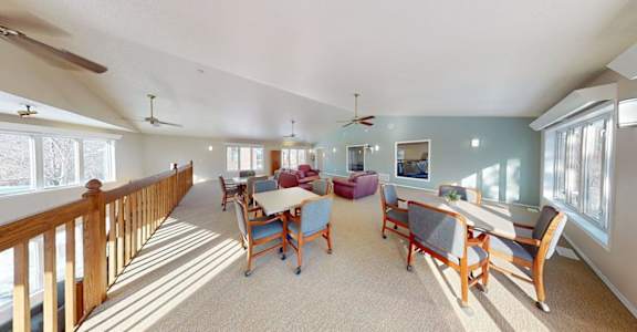 A sunny day in a spacious room with a long table and chairs.