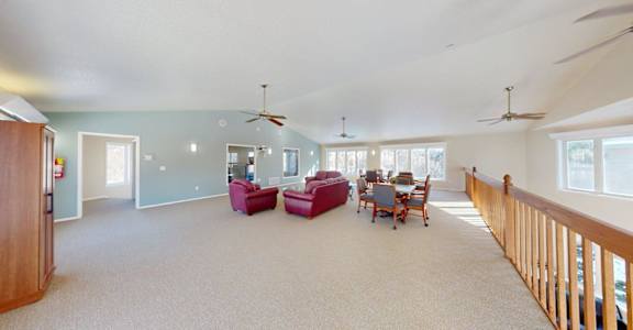 A spacious living room with a dining table and chairs.