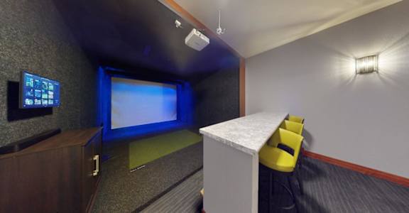 A room with a projector screen and a yellow chair.