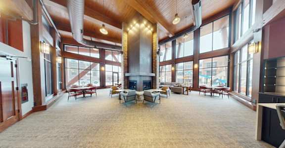 A large open room with a fireplace and lots of windows.