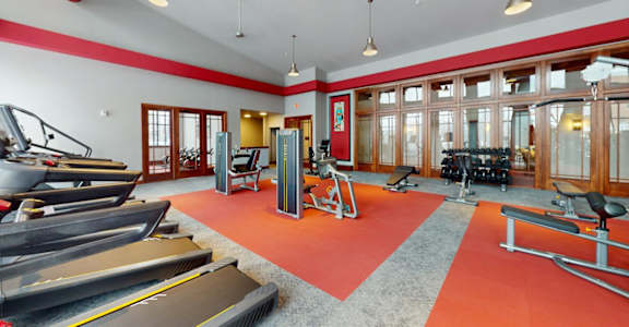 A gym with treadmills, weights, and exercise equipment.