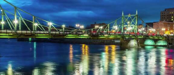 a view of a bridge over a river at night