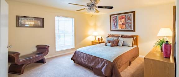 a bedroom with a bed and a ceiling fan