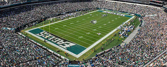 A large crowd of people is gathered in a stadium to watch a football game.