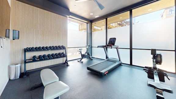 a gym with a treadmill and weights on the floor