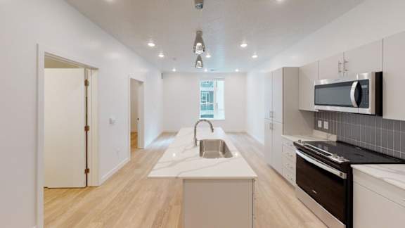 A modern kitchen with a long island in the middle.