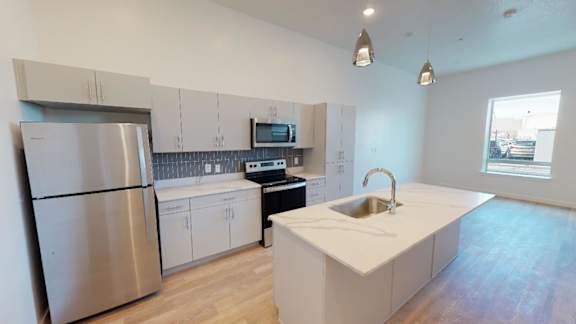 A kitchen with a stainless steel refrigerator and a white countertop.