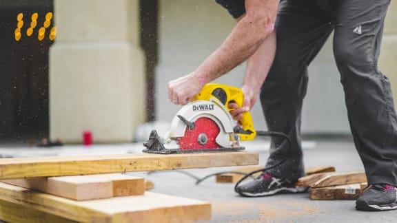 a man using a chainsaw on a piece of wood