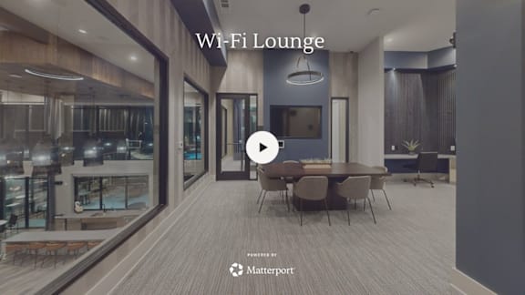 A modern lounge area with a video play button overlay.