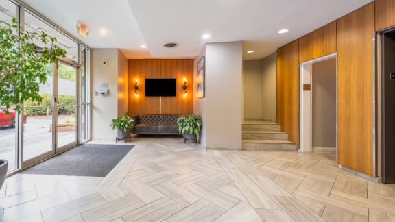 a lobby with a couch and a tv on the wall