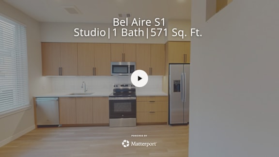 A kitchen with wooden cabinets and a stainless steel refrigerator.