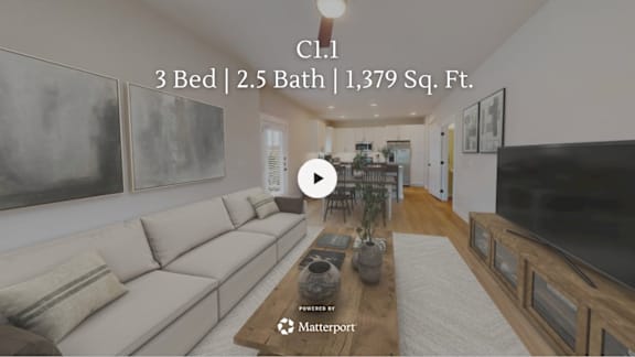 A living room with a couch, a coffee table, and a television.