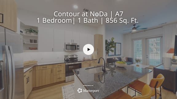 A kitchen with a refrigerator, sink, and a counter with a plant on it.