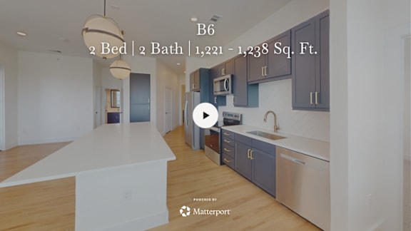 A kitchen with a white countertop and a play button overlay.