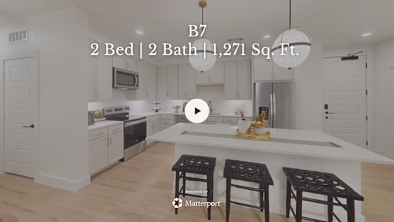 A kitchen with a bar stool in front of a counter.