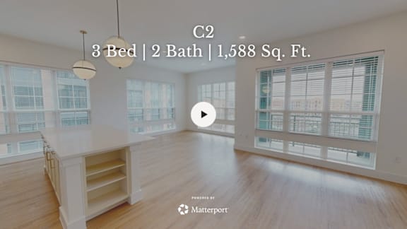 A spacious room with a large window and a wooden floor.