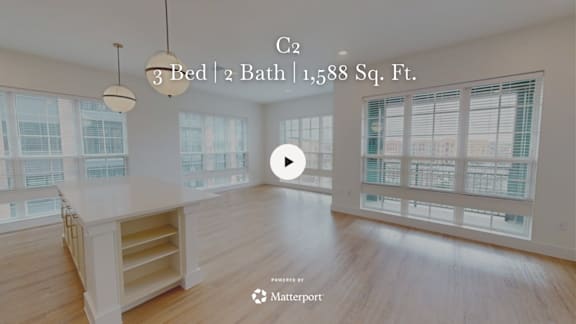 A spacious room with a wooden floor and a large window.