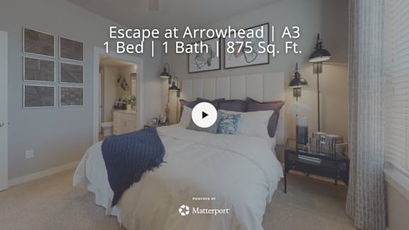 A bedroom with a bed, nightstand, and a window.
