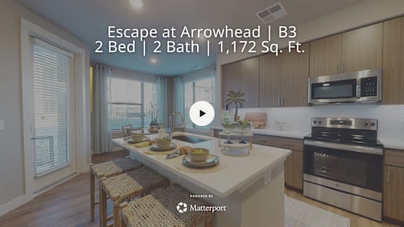 A kitchen with a dining table set for two and a view of the city.