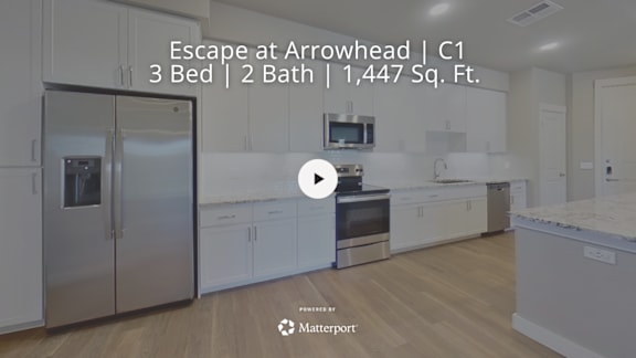 A kitchen with a refrigerator, microwave, and oven.