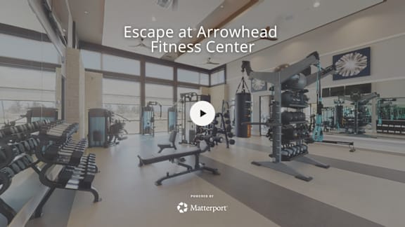 A gym with a variety of equipment and a play button overlay.