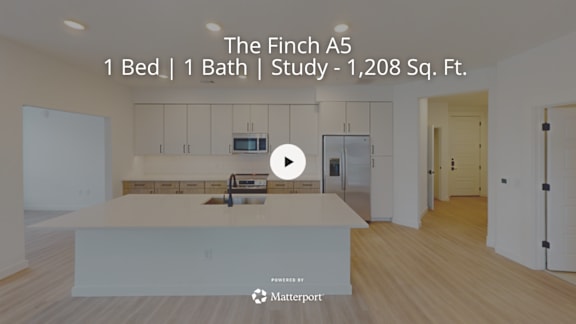 A room with a kitchen area and a study in a property called The Finch A5.