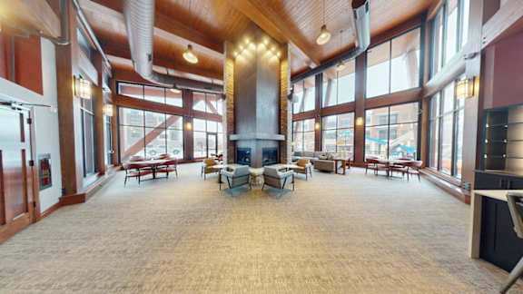 A large open room with a fireplace and lots of windows.
