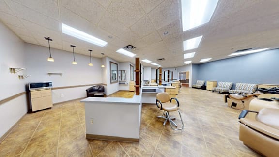 A spacious waiting room with a reception desk and multiple seating options.