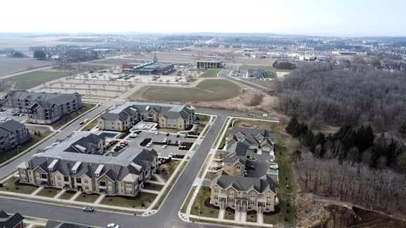 A bird's eye view of a residential area with houses and a park.