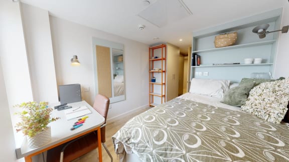 a bedroom with a bed and a desk with a computer