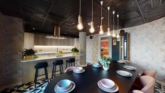 A modern dining room with a black table and chairs.