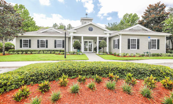 a white house with black shutters and a garden in front of it