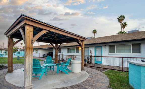 a patio with a table and chairs in front of a house