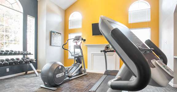 a gym with treadmills and exercise equipment at the district at highland village