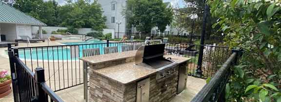 a rooftop deck with chairs and a table and a pergola at Village Club on Franklin, Southfield Michigan