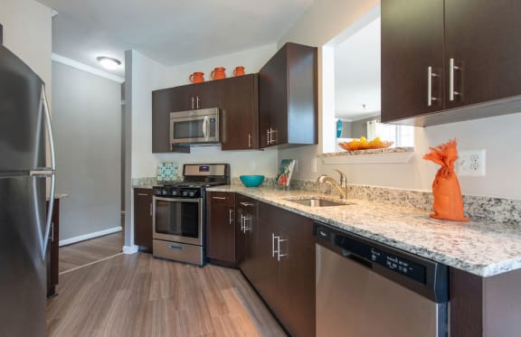 a kitchen with dark wood cabinets and granite countertops at Woodland Park, Virginia