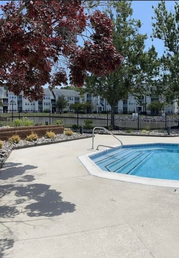 a swimming pool and a resort style pool with trees and buildings in the background