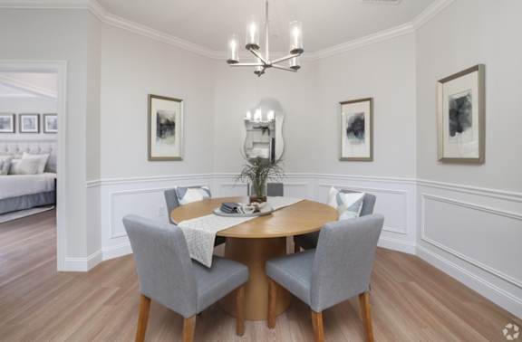 A dining room with a table and chairs.