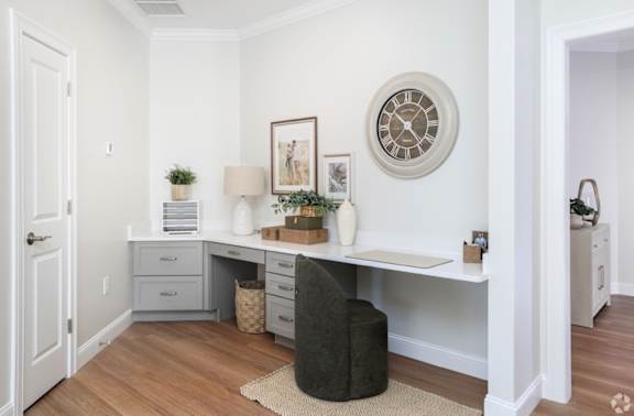 A white room with a desk and a clock on the wall.