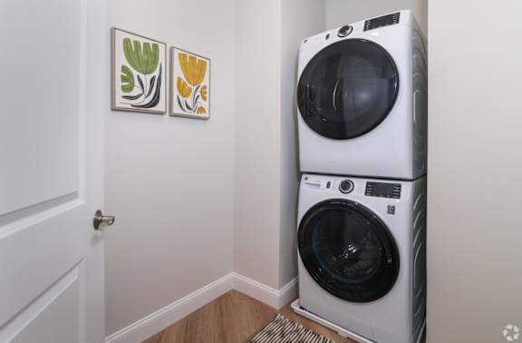 A white front load washing machine in a laundry room.
