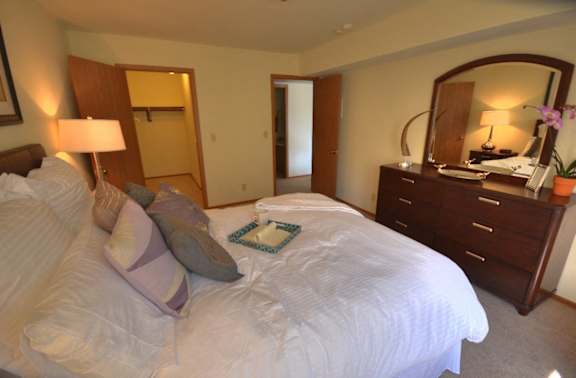 a bedroom with a large bed and a dresser with a mirror