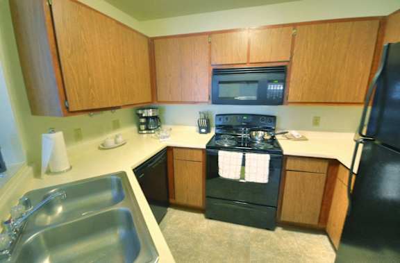 a kitchen with black appliances and wooden cabinets