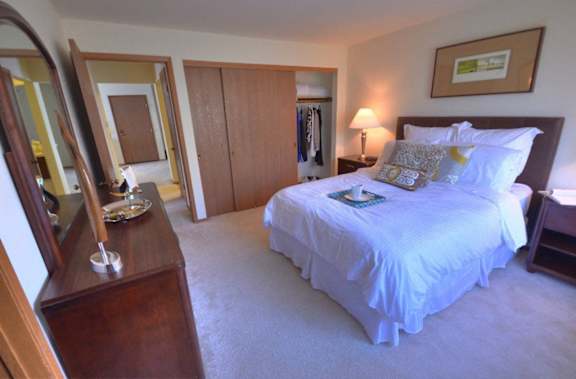 a bedroom with a bed and a dresser and a mirror