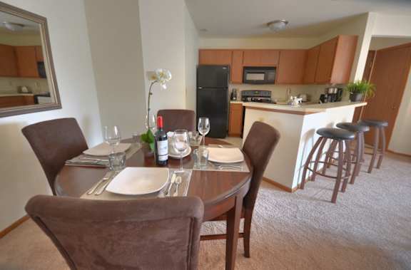 a dining room with a table and chairs and a kitchen