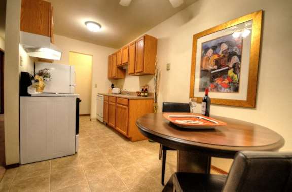 a kitchen and dining room with a table and a painting