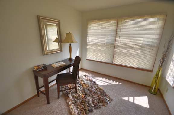 a home office with a desk and a lamp