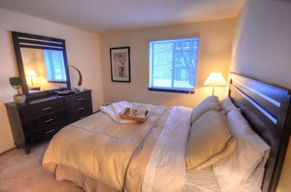 a bedroom with a bed and a dresser and a window