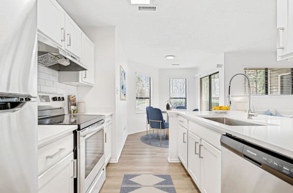 A modern kitchen with white appliances and cabinets. at Bridges at Mallard Creek Apartment Homes, Charlotte, NC, 28269
