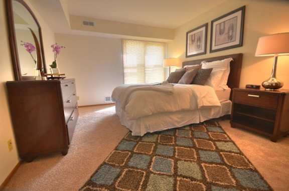 a bedroom with a bed and a dresser and a window